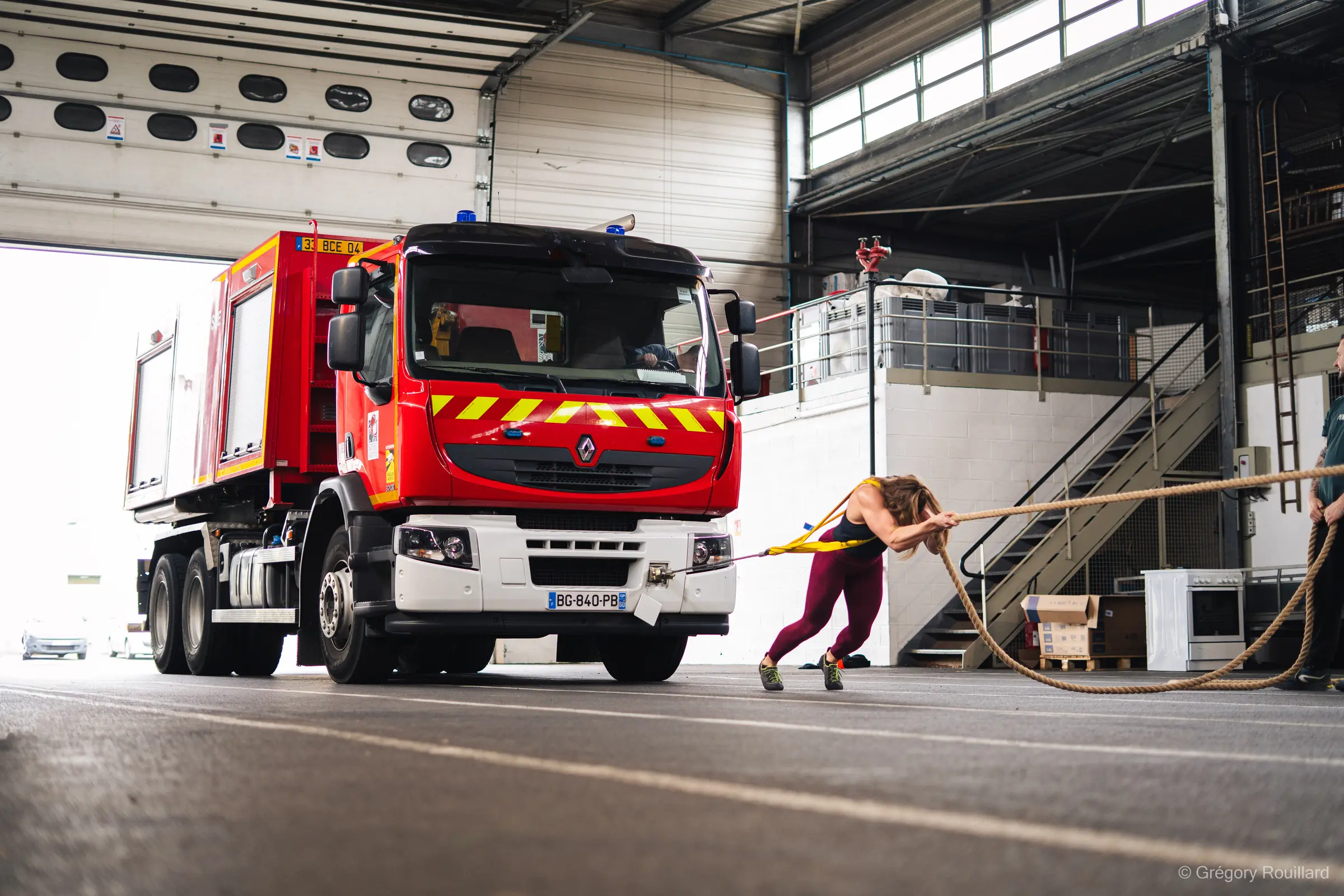 Angeline tire un camion de pompiers pendant un effort StrongWoman